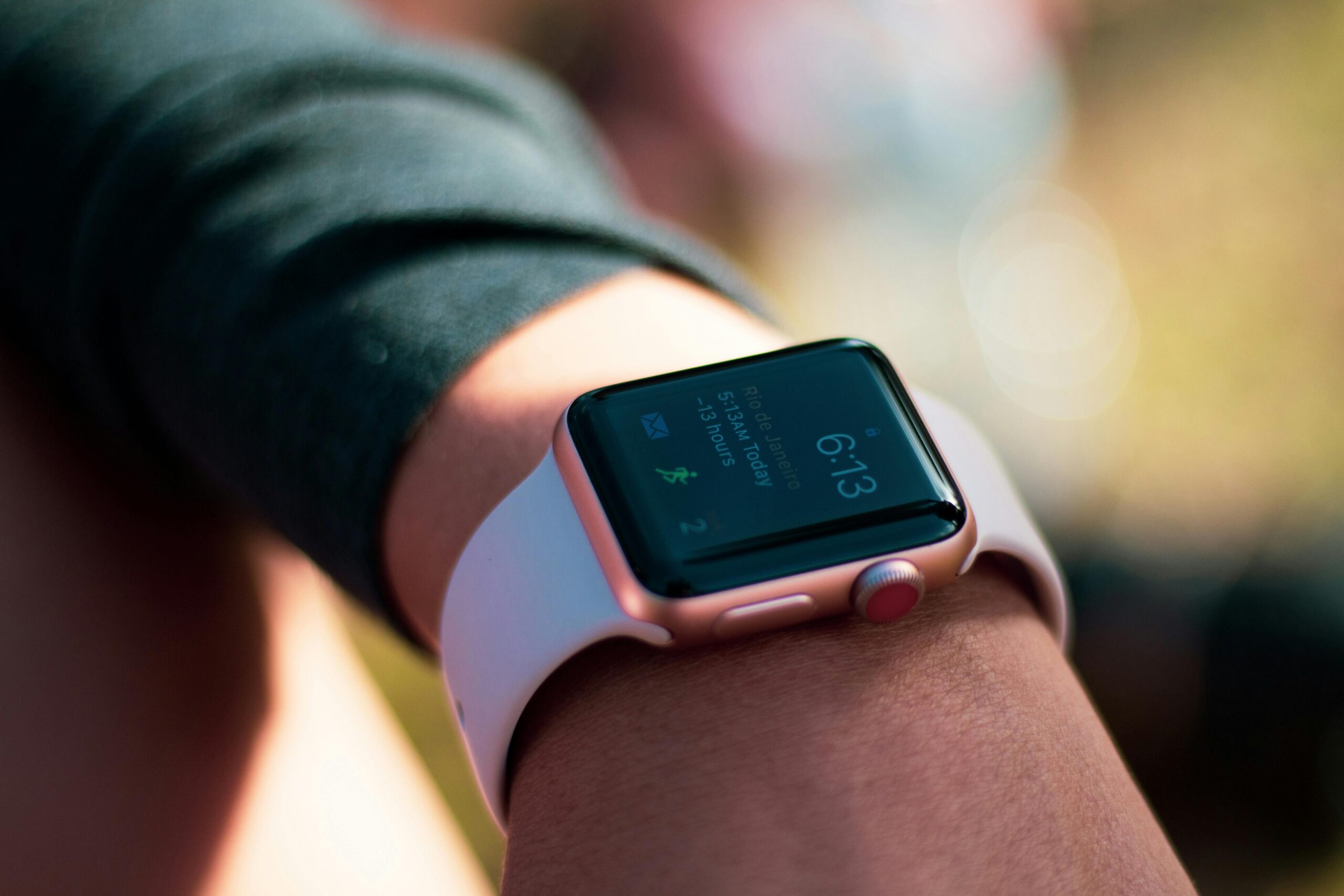 Home Smartwatch with digital screen displaying 6:13, worn on wrist outdoors.